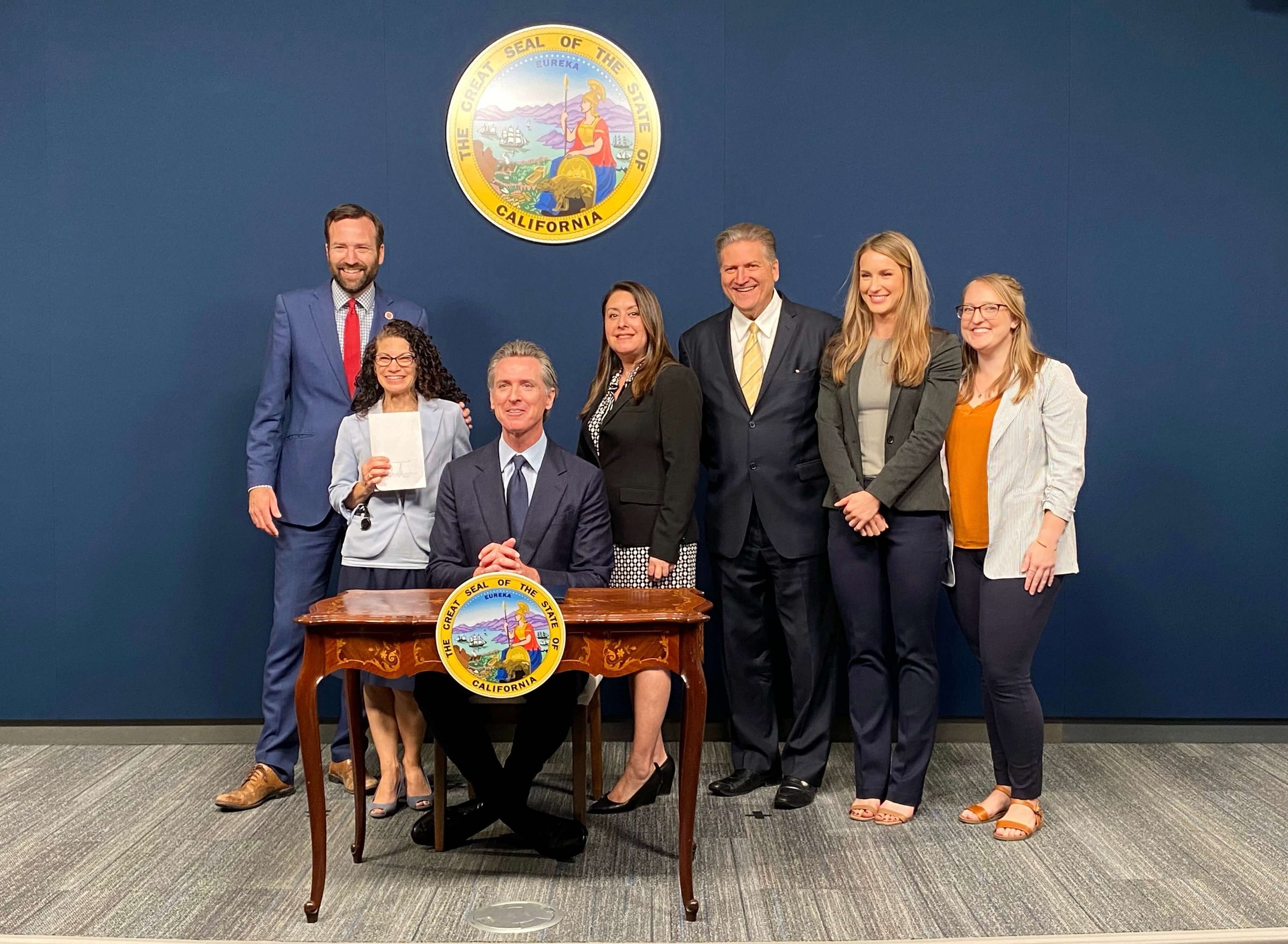 Governor Gavin Newsom signs SB 54 on June 30, 2022, joined by Senator Ben Allen, Assemblymember Luz Rivas, and staff at the state Capitol.